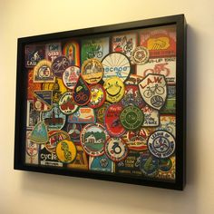 there is a framed picture with many different badges on the wall in this room and it looks like they are made out of beer caps