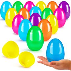 a hand is holding an egg in front of many colored eggs