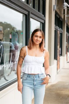 The Easy Does It Babydoll Top offers an easy fit with delicate channeled elastic throughout. The unique detailing on the straps and neckline gives this simple white top some texture, along with the subtle peplum, this top is perfectly flattering and feminine! Pair with your favorite denim jeans, beige carpenter pants, and virtually any pair of shorts! white tank top babydoll style hemline channeled elastic at neckline, straps, and under bust fits true to size, model wears size small 60% rayon, 4 White Smocked Bodice Tank Top, White Smocked Bodice Sleeveless Tank Top, White Casual Camisole With Ruffled Straps, Casual White Camisole With Ruffled Straps, White Ruffled Straps Tank Top For Day Out, White Tank Top With Ruffled Straps For Day Out, Carpenter Pants, Babydoll Style, Romper And Jacket