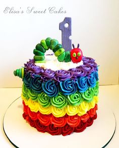 a very colorful cake with a one on top that is made to look like the very hungry caterpillar