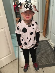 a young boy wearing a dalmatian shirt and hat