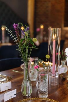 a wooden table topped with vases filled with different types of flowers and greenery