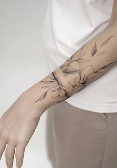 a person with a flower tattoo on their arm and the other hand is holding something