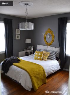 a bedroom with gray walls and yellow accents on the bed, along with two windows