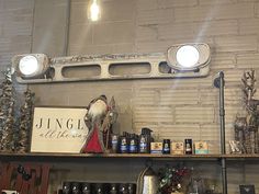 a shelf filled with bottles and lights next to a brick wall