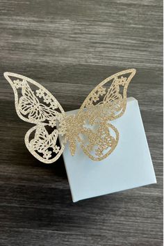 a white and gold butterfly on top of a box