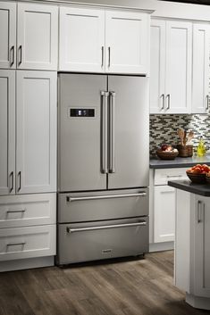 a kitchen with white cabinets and stainless steel appliances