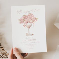 a person holding up a card with pink flowers in the center and text that reads, she is going to the art