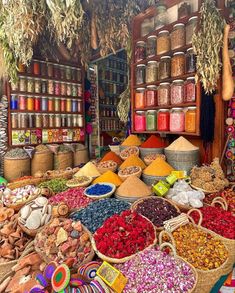 an outdoor market with lots of different types of spices and herbs on display in baskets