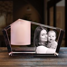 a glass photo frame with a pink candle and a christmas tree in the background