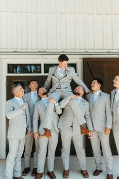 a group of men standing next to each other in front of a white barn door