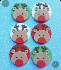 four decorated christmas buttons with reindeer faces on blue and white polka doted paper background