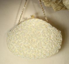 I am SO happy to be offering this beyond beautiful vintage collectible high-end designer "Richere by WALBORG" Art Deco hand beaded warm ivory sequins and white bead gold flapper purse with rhinestone detail perfect for the Bride. I can't tell you how much I adore the design of this purse!  This bag is in near PRISTINE vintage condition. If you've ever seen one of these Walborg purses in person you know that photos are not doing it justice or capturing the attention to detail adequately.  It is completely covered with closely hand sewn ivory sequins and white seed beads in a gorgeous vine pattern.  The beadwork is done over ivory statiny fabric and the design is the same front and back. The purse closes with a rhinestone adorned kiss clasp. Bag measures 8 inches wide and is 6 inches high no Vintage White Embellished Bags, Vintage White Embellished Evening Bag, Vintage Evening Bag With Handwork For Formal Occasions, Cream Evening Bag With Pearl Embroidery For Wedding, Embellished Cream Evening Bag For Wedding, White Evening Bag With Handwork For Wedding, Beige Pearl Embroidered Evening Bag For Wedding, Vintage Pearl Embroidered Evening Bag For Events, Vintage Evening Bag With Pearl Embroidery For Events