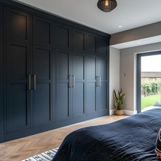 a bedroom with dark blue cabinets and a large bed in the middle, along with a potted plant