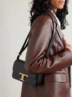 Tod's sleek shoulder bag is as timeless as they come. It's been made in Italy from smooth, supple leather and defined by statement gold-tone 'T' hardware at the front. The internal slip pockets keep your phone, cards and makeup organized in the evenings. Timeless Tan Shoulder Bag For Office, Sleek Formal Shoulder Bag With Branded Hardware, Timeless Tan Shoulder Bag With Gold-tone Hardware, Timeless Tan Shoulder Bag With Branded Hardware, Classic Tan Shoulder Bag For Business, Timeless Tan Shoulder Bag For Work, Formal Tan Flap Shoulder Bag, Modern Tan Flap Bag With Gold-tone Hardware, Tan Shoulder Bag With Gold-tone Hardware For Everyday Luxury