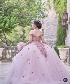 a woman in a pink dress is standing outside