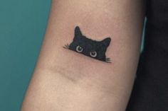 a black cat tattoo on the arm