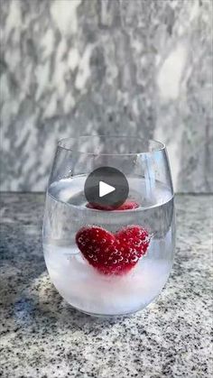 a bowl filled with ice and raspberries on top of a marble countertop