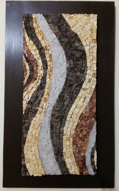 an art piece made out of different types of stones and wood with black frame on the wall