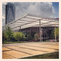 an empty park with steps leading up to it and a large building in the background