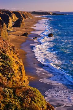 the beach is lined with cliffs and blue water