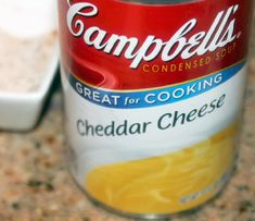 a can of soup sitting on top of a counter next to a container of cheese