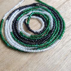 This beautiful waistbead was made with emerald green, iridescent and black glass seed beads.Waistbead length: 50 inches Strung on strong, cotton cord with 2 clear anchor beads (for adjustment) and 2 knots. Tie on, permanent waistbeads. Waist beads have been worn for centuries in African tradition, and the uses are endless. From adornment and weight management, all the way to signs of maturity and femininity, the diversity of waist beads make them appealing pieces of jewelry to own. They are gene Green Beaded Necklace With Black Round Beads, Green Tiny Beads Waist Beads Gift, Green Tiny Round Beads Waist Beads, Green Waist Beads For Gift, Green Beaded Waist Beads For The Beach, Green Beaded Waist Beads For Beach, Green Beaded Necklaces With Black Beads For Festivals, Green Beaded Necklace With Black Beads For Festivals, Green And Black Beaded Necklaces For Festivals