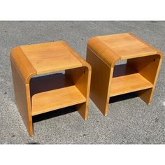 two wooden side tables sitting on top of cement