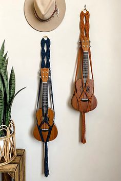 three hats hanging on the wall next to a hat rack with two saddles and a cowboy's hat