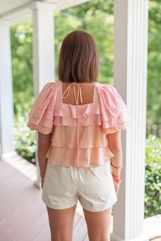 Mauve and pink colorblock ruffle layer tiered top with puff sleeves Ruffed Sass is this Summer's prettiest little top! Mauve and pink colorblock fabric in ruffle layered tiers, featuring a square neckline and ruffle layer tiered puff sleeves. Perfect for any upcoming occasion, this babe will make you stand out in style! Dress her up with a skirt and heels, or wear her casually in a boho style with shorts or jeans, and sandals (or barefoot at the beach). True to size fit; relaxed silhouette Model Summer Puff Sleeve Top With Ruffles And Square Neck, Pink Ruffled Square Neck Top, Pink Square Neck Top With Ruffles, Pink Ruffled Straps Top For Brunch, Pink Tops With Ruffled Straps And Details, Tiered Pink Tops For Spring, Spring Pink Puff Sleeve Top With Ruffles, Square Neck Puff Sleeve Top With Ruffles For Brunch, Chic Pink Puff Sleeve Top With Square Neck