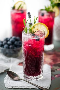 the blueberry lavender lemonade is served in a glass with ice and garnish