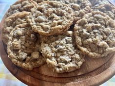 four cookies on a wooden platter sitting on a table