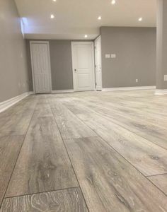 an empty room with wood floors and white doors