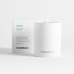 a white candle sitting next to a business card