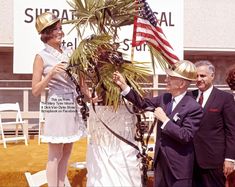 two men and one woman are dressed up in costumes for an event with flags on them