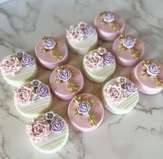 there are many pink and white heart shaped cakes on the marble counter top with flowers