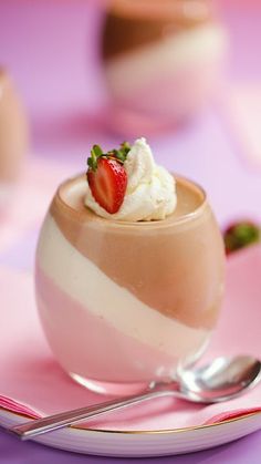 there is a small dessert with whipped cream and strawberries in the bowl on the plate