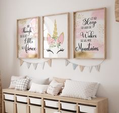 three framed unicorns are hanging on the wall above a bench with pillows and storage bins