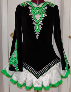 a woman's black and green latin dance dress with white ruffles on the bottom