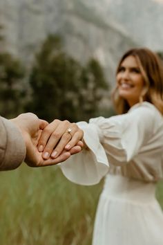 a man and woman holding hands in the grass