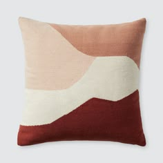 a red, pink and white pillow with an abstract design on the front cover is shown