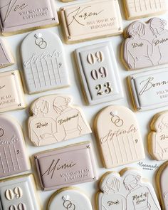 wedding cookies are arranged in rows on a table with names and date written on them