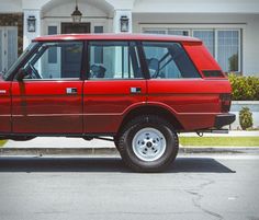 a red suv parked in front of a house