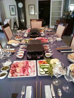 a dining table is set with food and silverware