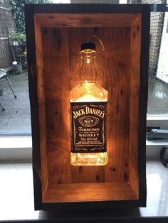 an illuminated jack daniels bottle in a wooden box