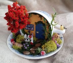 a plate that has some plants on top of it and a small house in the middle