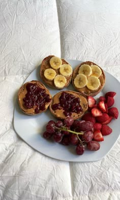 a white plate topped with toast, fruit and banana slices on top of a table