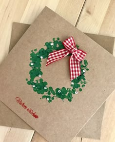 a brown card with green and red confetti on it, sitting on top of a wooden table