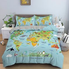 a bed with a blue comforter and two pillows that have different animals on them