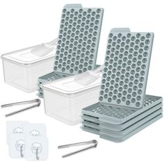 four plastic containers with spoons and tongs in them next to each other on a white background